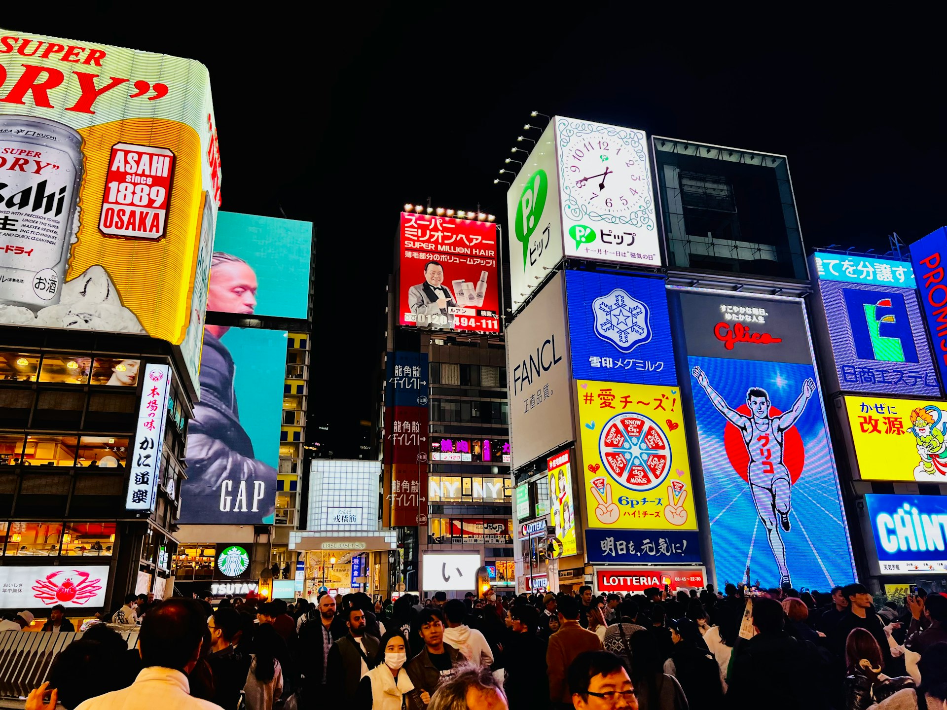 a crowded city street filled with lots of billboards